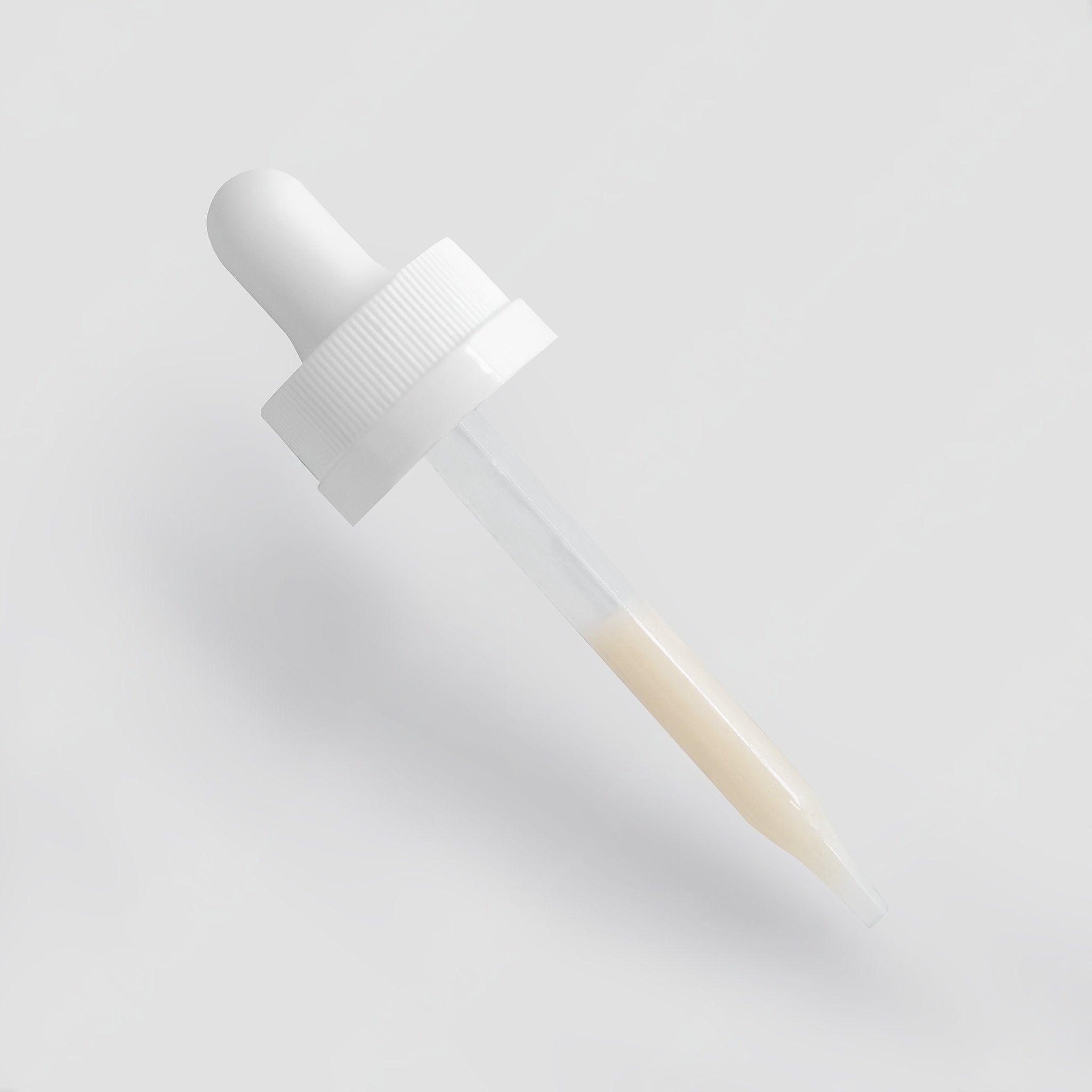 White dropper bottle on a light gray background