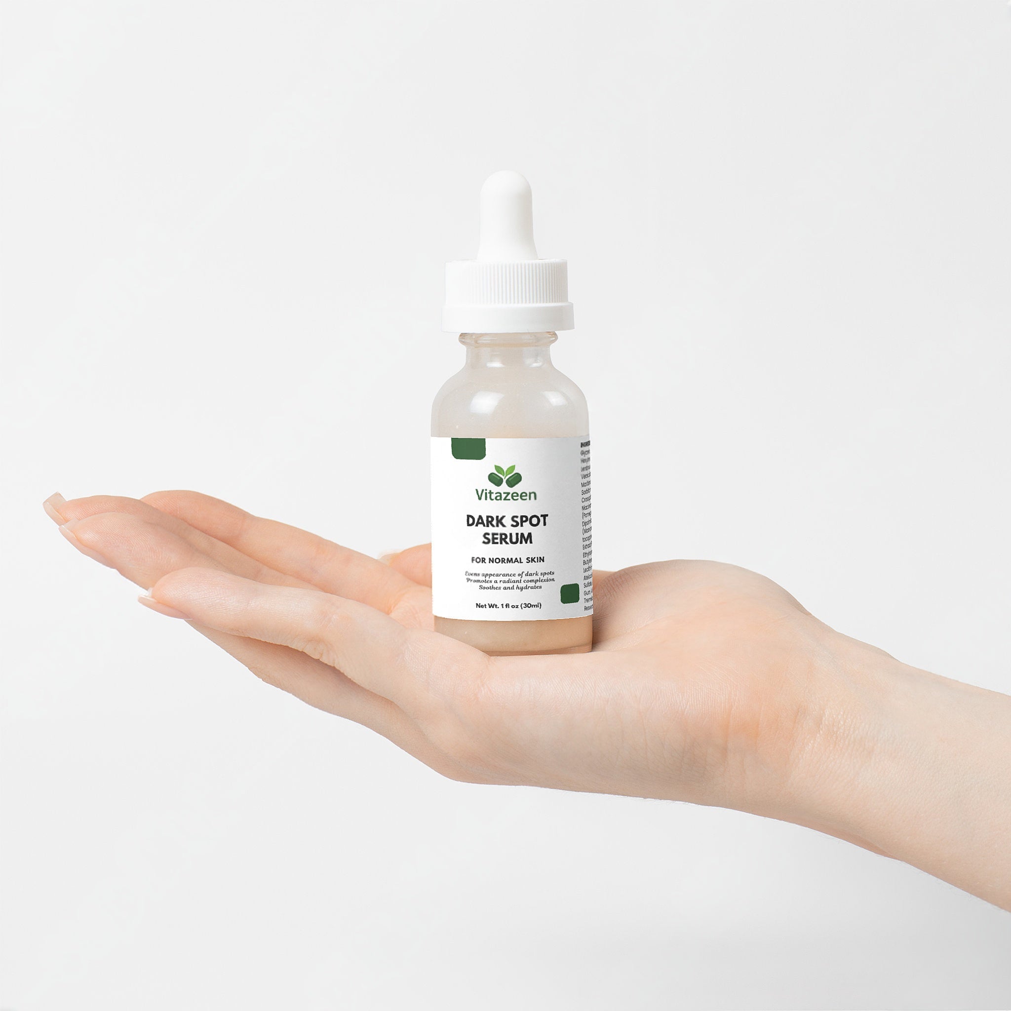 VitaGreen Dark Spot Serum bottle held in a hand against a white background